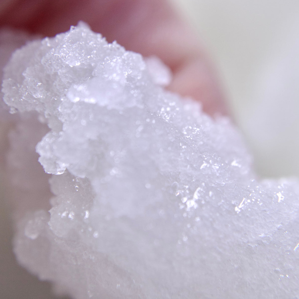 A close up photo of Liney Cosmetics Body Scrub held in hand.